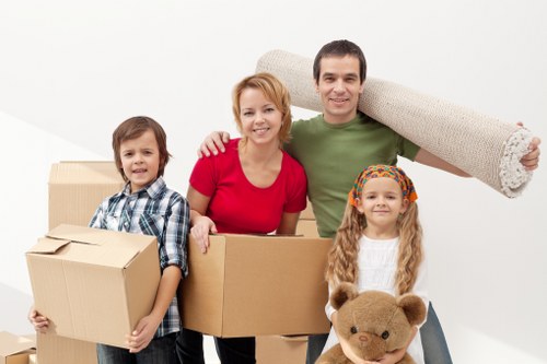 Professional movers carrying furniture through a Pimlico property